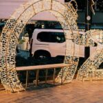 Illuminated 2025 sign on city street with decorative lights creating a festive atmosphere.