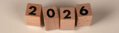 Wooden cubes forming the year 2026 on a neutral background.